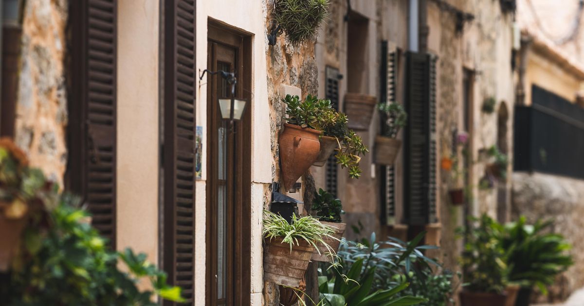Enge Gasse in Valldemossa mit Blumentöpfen und Steinmauern