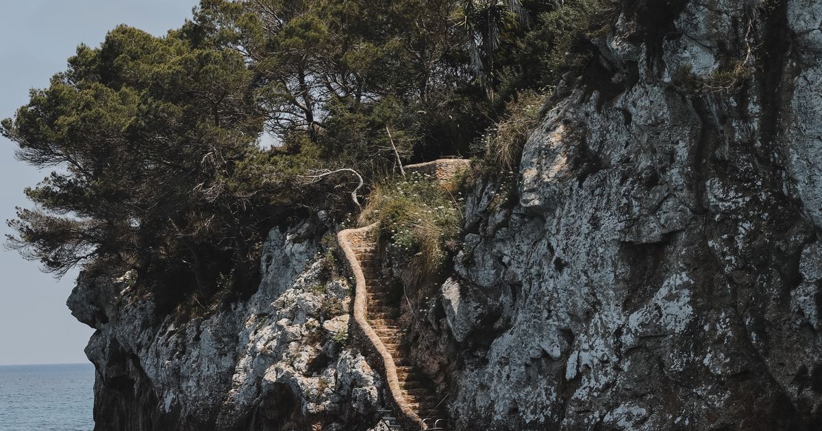Cala Llombards Bucht mit Felsklippen und türkisem Wasser